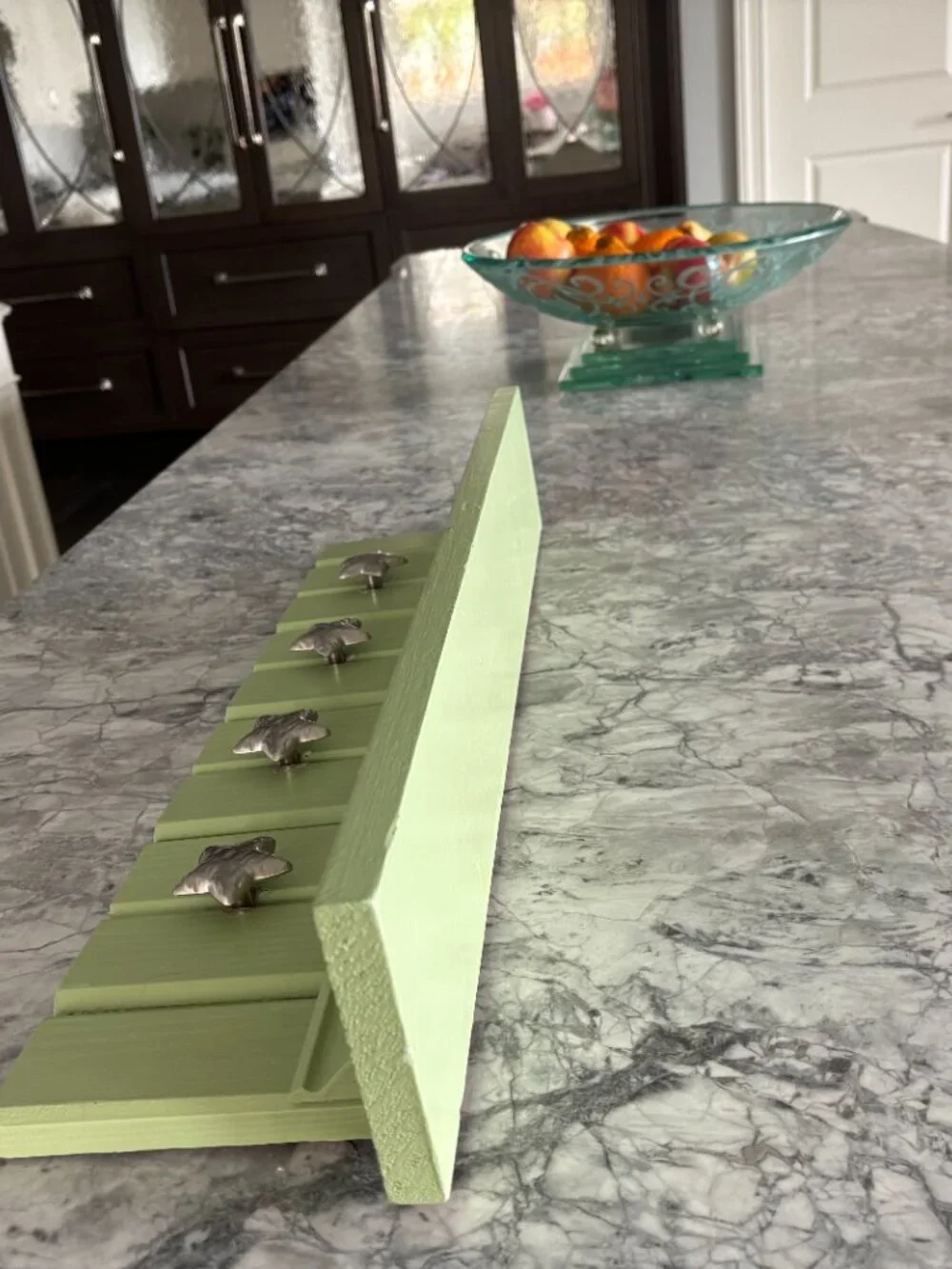 Light green, handmade wooden wall shelf with hanging star knobs for hanging